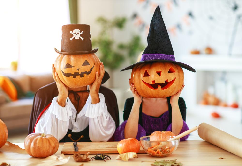 Halloween concept couple of people dressed as witches and vampires with pumpkins for heads